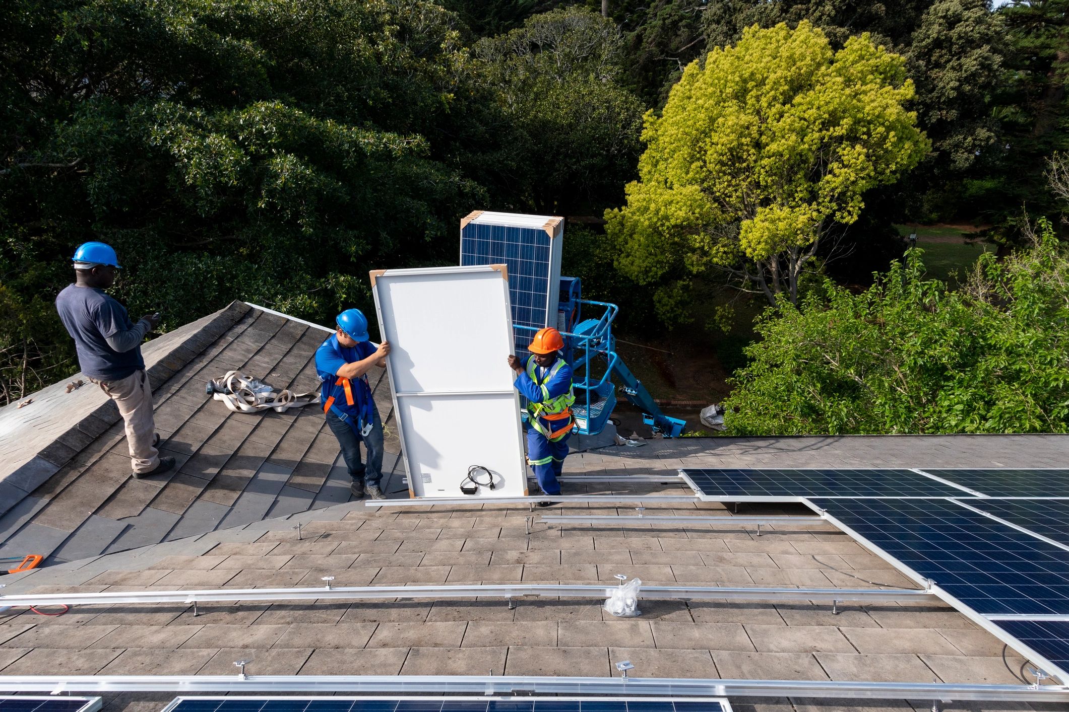 High angle view men unloading solar panels onto roof